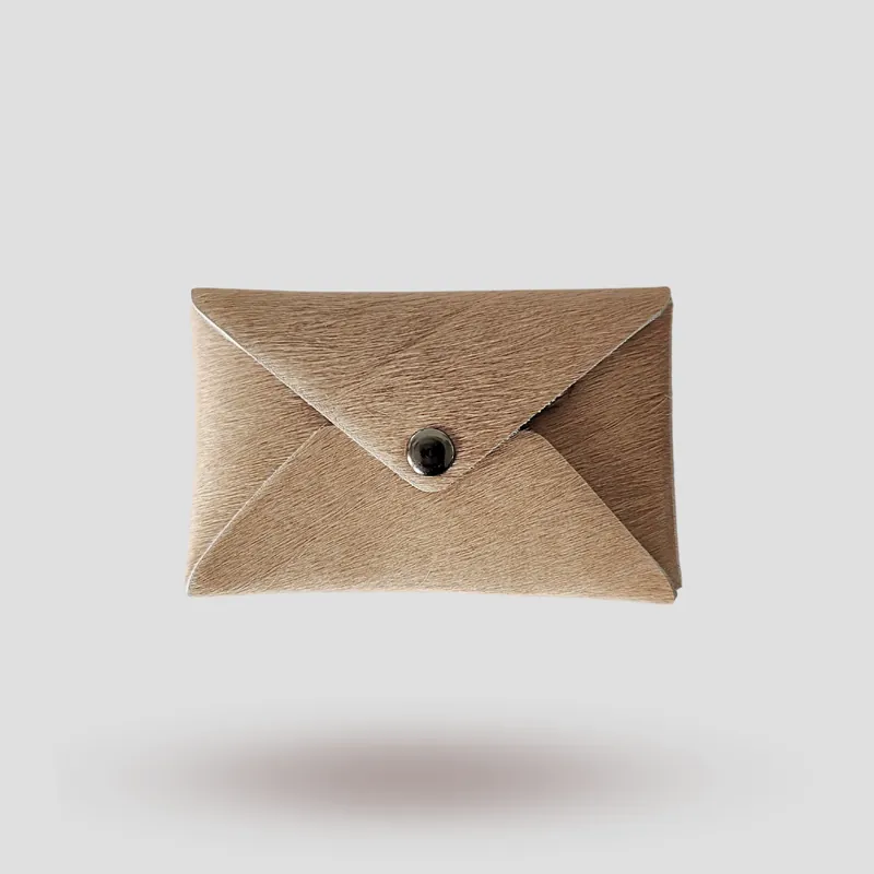 A custom gift card case handcrafted in beige premium hair-on leather.