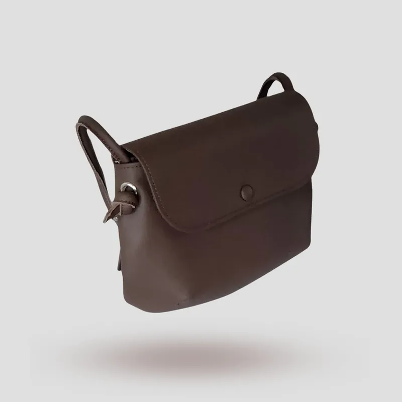 A signature crossbody bag handcrafted in brown premium cowhide leather.