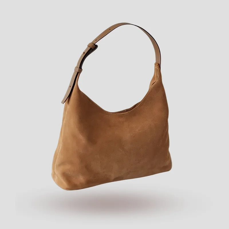 A custom hobo bag handcrafted in beige premium suede with a mocha premium cowhide leather adjustable strap.