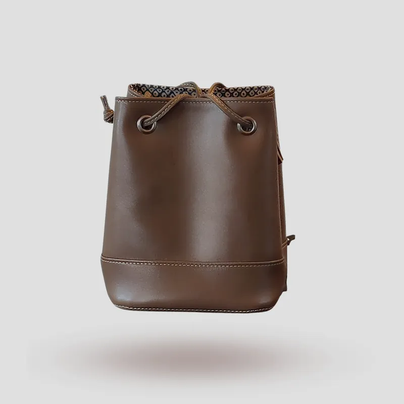 A custom bucket bag handcrafted in mocha premium cowhide leather.
