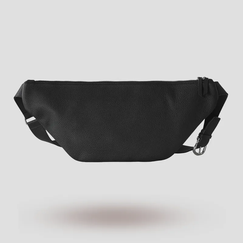 A custom sling bag handcrafted in black premium French shrunken calfskin with a forest green goatskin lining.
