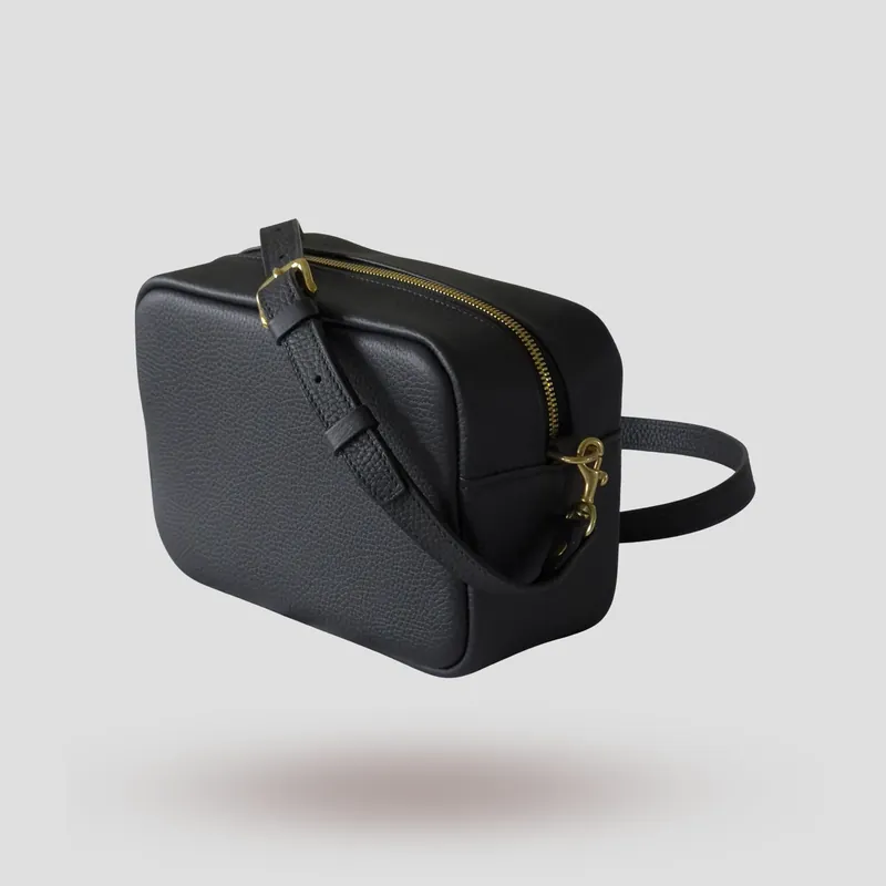 A custom piece handcrafted in black premium Taurillon leather with a teal green goatskin lining.
