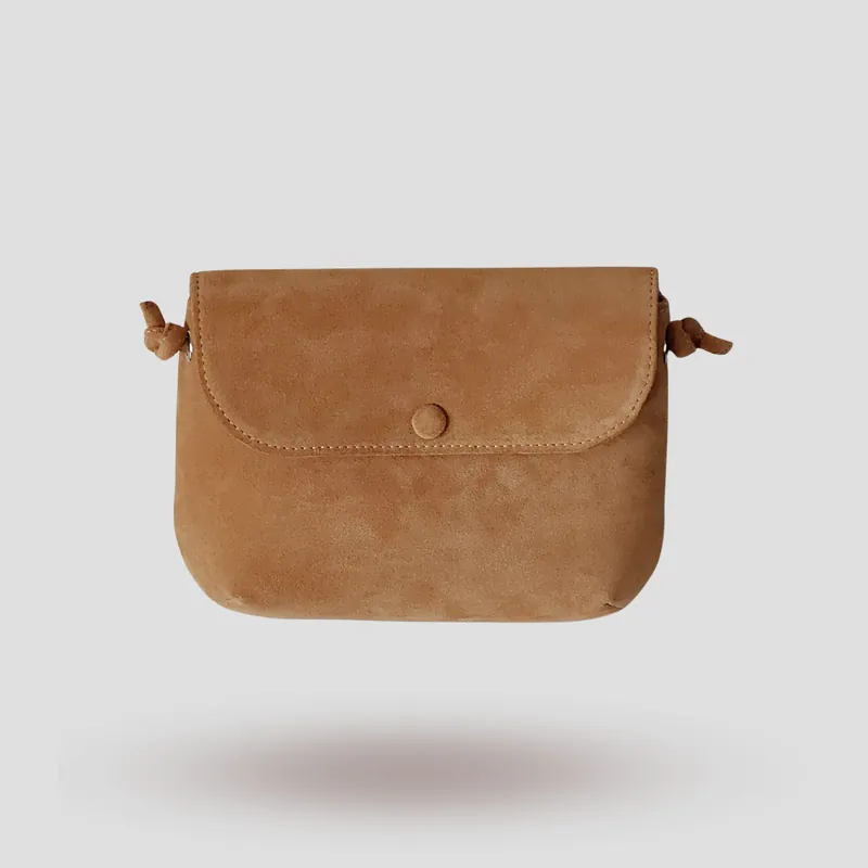 A signature crossbody bag handcrafted in beige premium suede.
