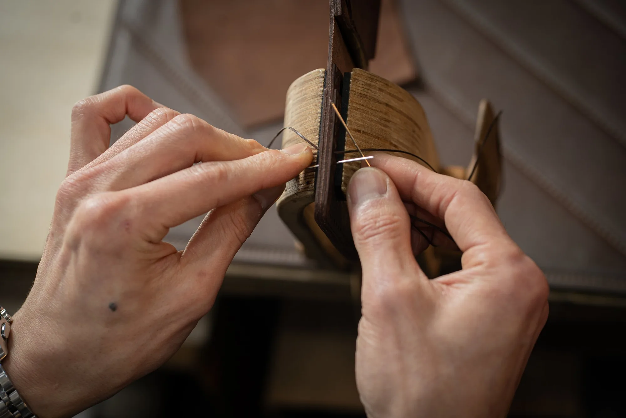 Joe hand stitching a leather piece, photographed by Dani Cruz Photography