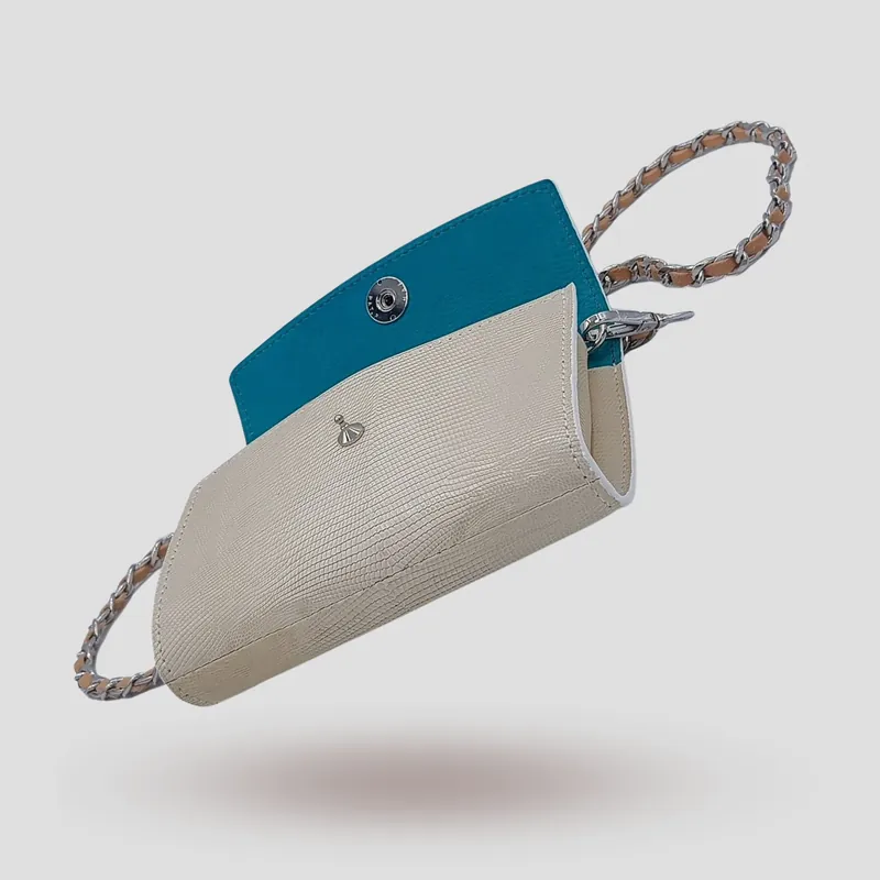 A custom clutch handcrafted in off-white lizard leather with a blue premium suede lining.