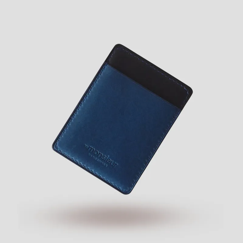A custom cardholder handcrafted in marine blue and black premium vegetable-tanned leather.