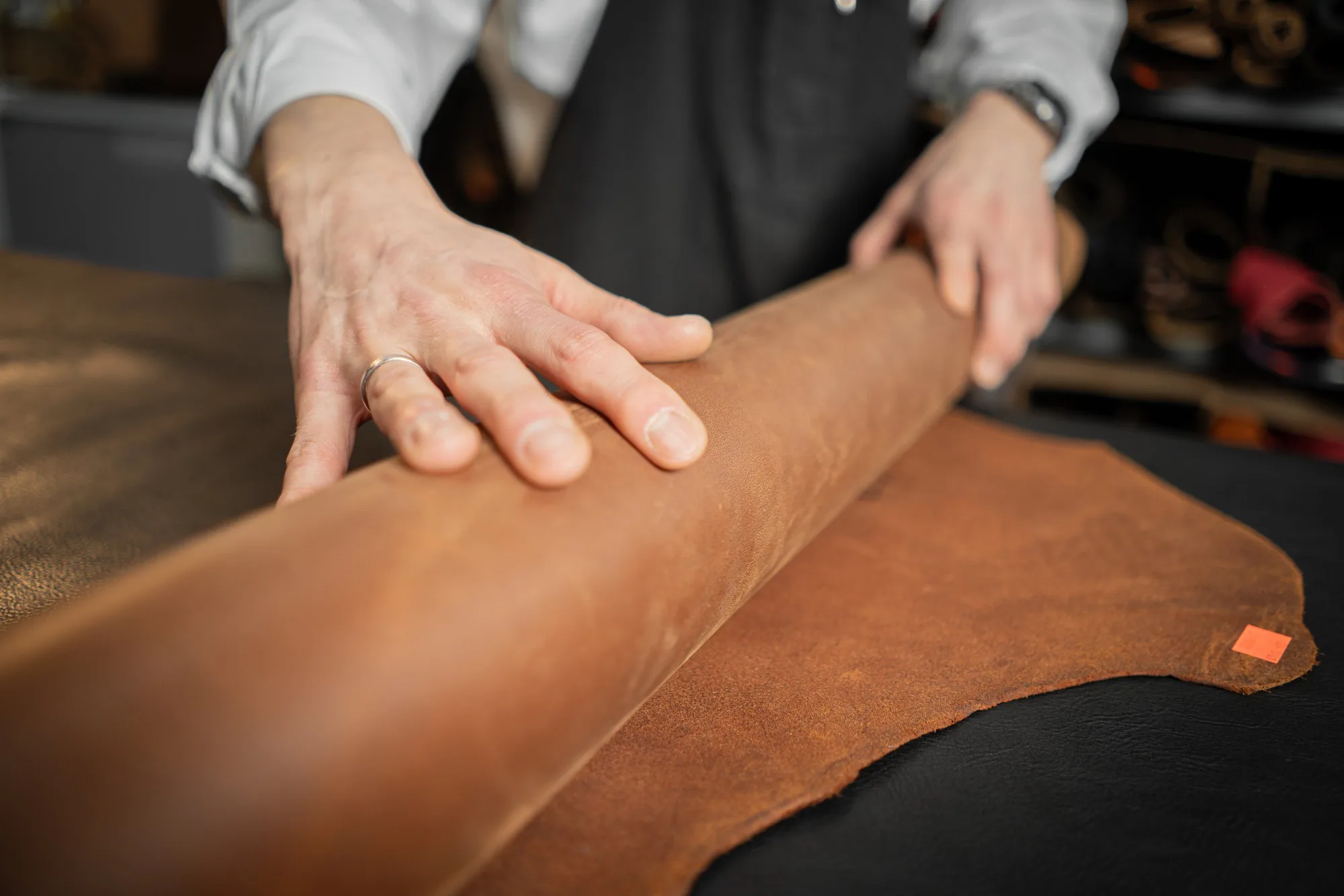 Joe touching a leather hide in his atelier