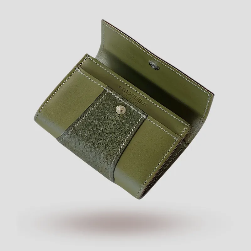 A custom wallet handcrafted in olive green premium cowhide leather, featuring a bold, asymmetrical wrap accent in salmon leather, paired with a supple goatskin lining.