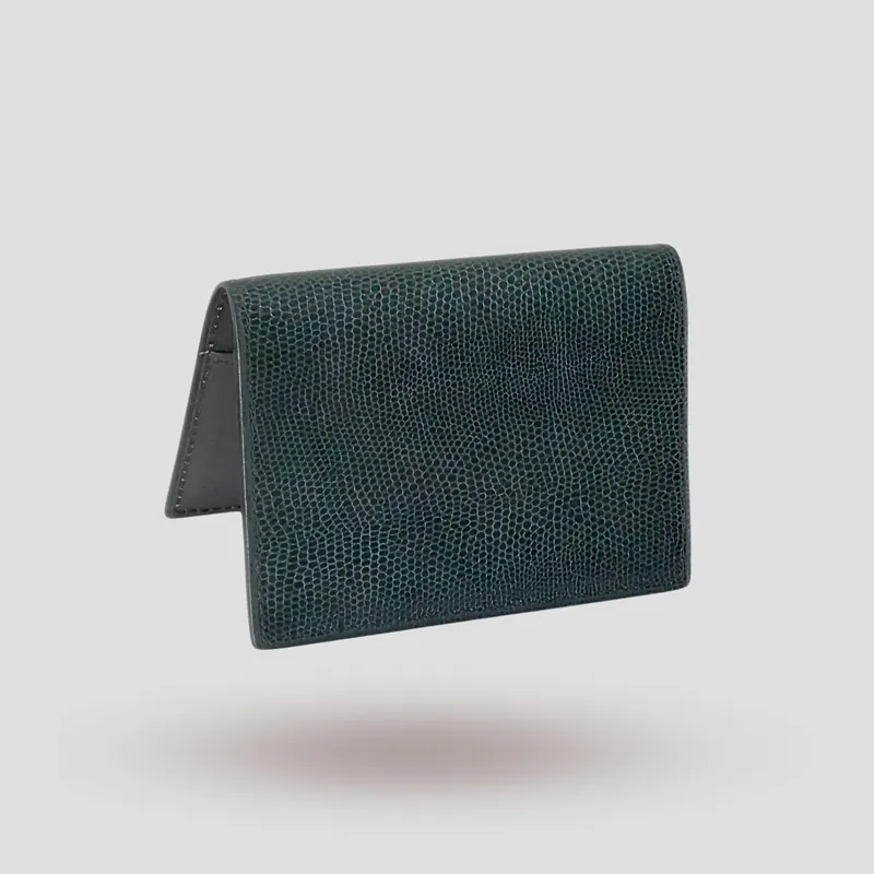A custom passport cover handcrafted in dark green lizard-embossed premium cowhide with a mocha goatskin lining.