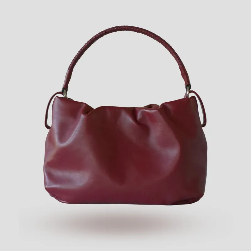 A custom soft mini bucket bag handcrafted in deep wine red full-grain aniline calfskin with a burgundy lambskin lining.