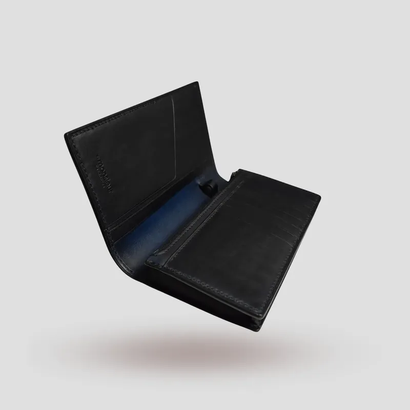 A custom long wallet handcrafted in black premium vegetable-tanned cowhide leather on the outside, and oiled Buttero navy blue vegetable-tanned cowhide leather inside.