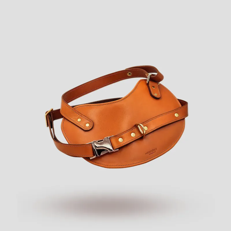 A custom dog harness handcrafted in orange premium cowhide leather.