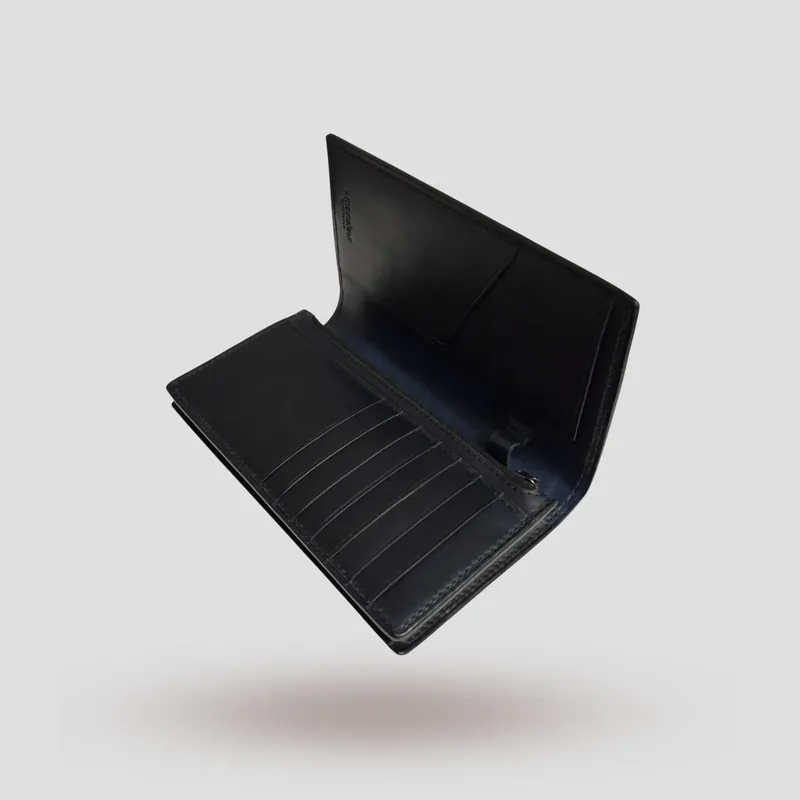A custom long wallet handcrafted in black premium vegetable-tanned cowhide leather on the outside, and oiled Buttero navy blue vegetable-tanned cowhide leather inside.