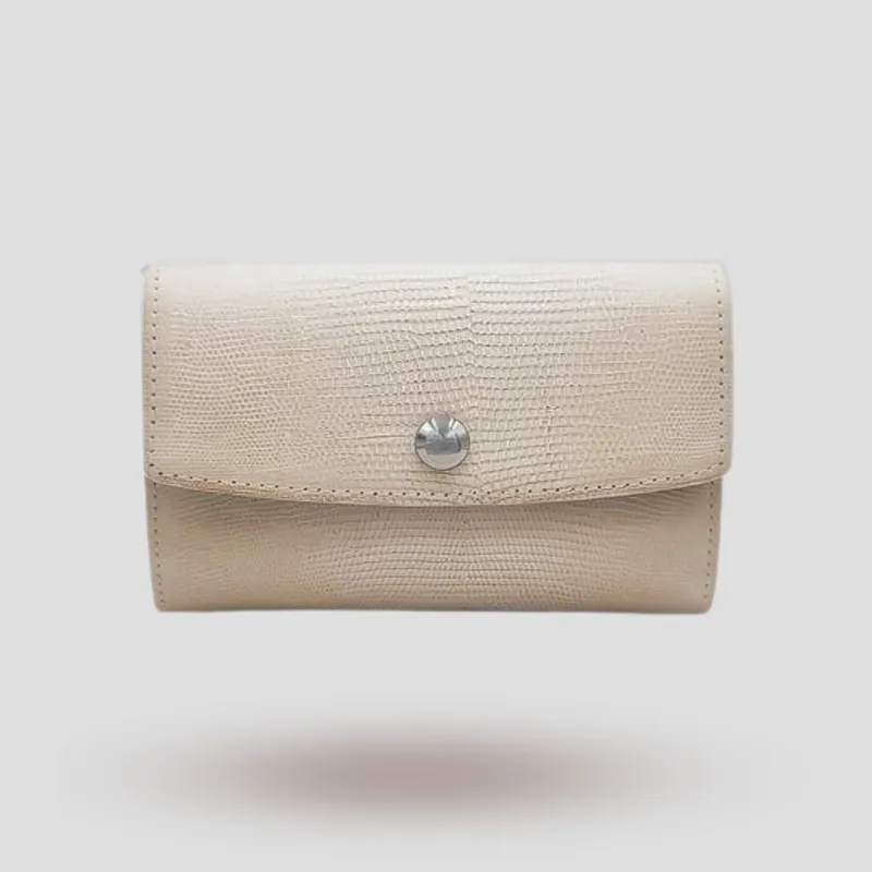 A custom clutch handcrafted in off-white lizard leather with a blue premium suede lining.