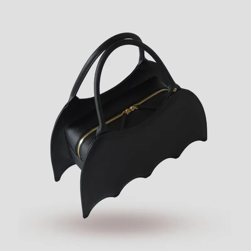 A custom bat-shaped handbag, handcrafted in black Epsom full-grain leather, with a grommet at the base of the handle for attaching charms.