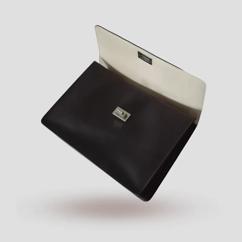 A custom briefcase handcrafted in dark-chocolate premium cowhide leather with an off-white goatskin lining.
