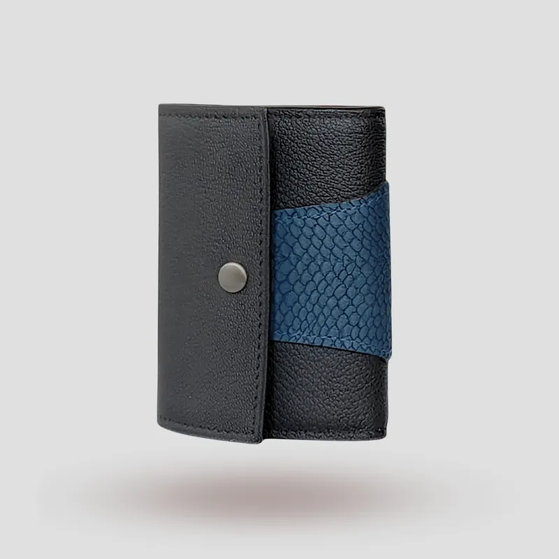 A custom wallet handcrafted in black premium cowhide leather, featuring a bold, asymmetrical wrap accent in salmon leather, paired with a supple goatskin lining.