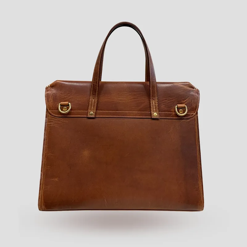 A custom crossbody bag/briefcase handcrafted in cognac premium Horween oil pull-up leather.