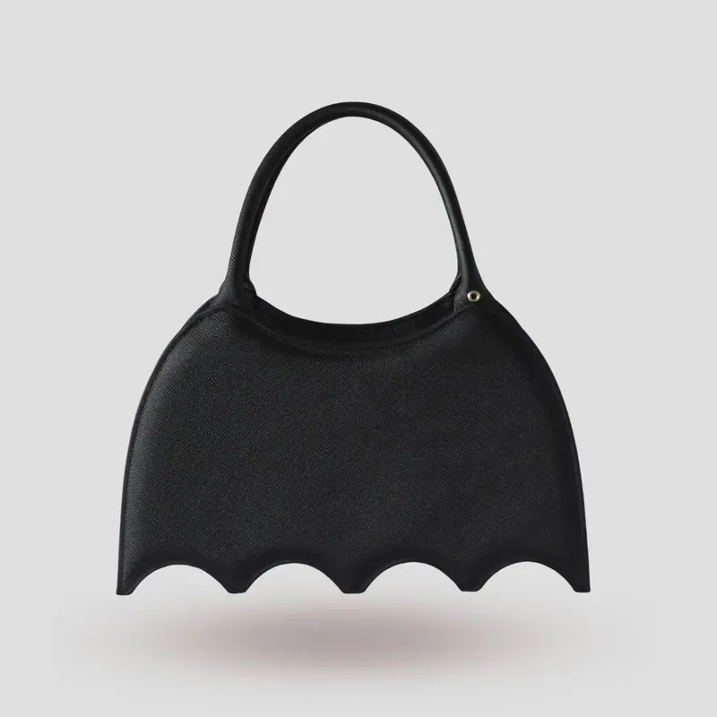 A custom bat-shaped handbag, handcrafted in black Epsom full-grain leather, with a grommet at the base of the handle for attaching charms.