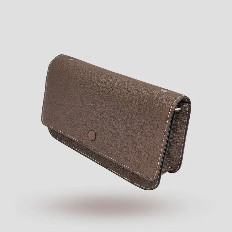 A custom pochette bag handcrafted in taupe/mocha premium cowhide leather.