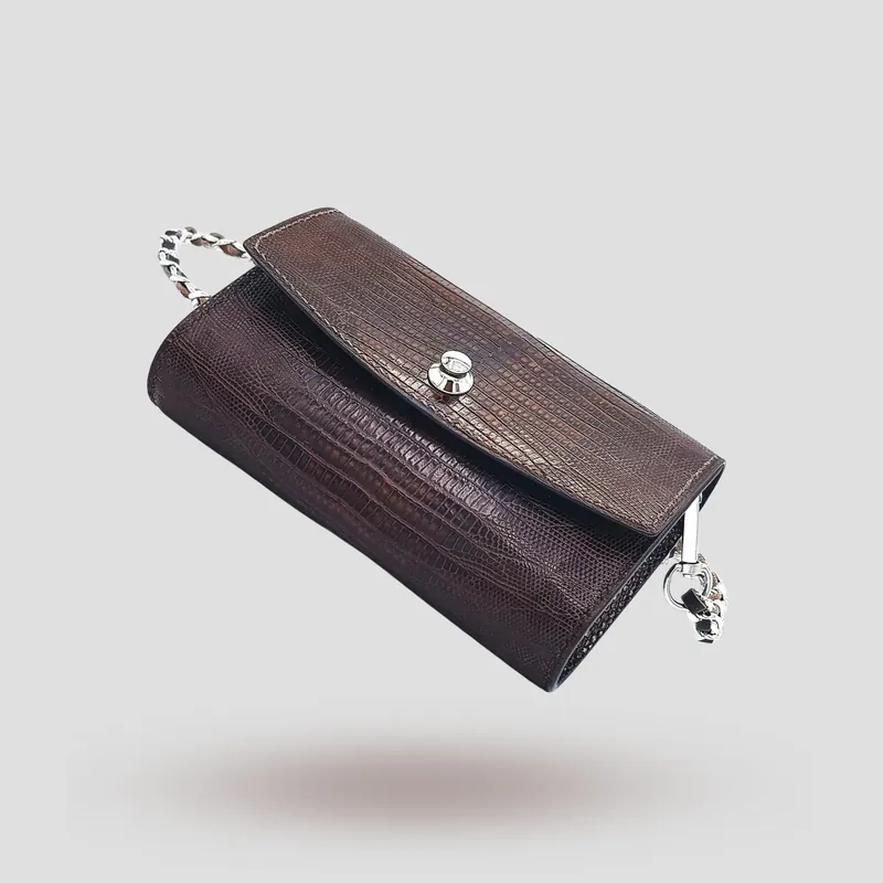 A custom clutch handcrafted in brown lizard leather with a black premium cowhide lining.