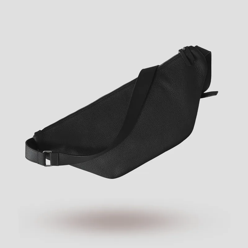 A custom sling bag handcrafted in black premium French shrunken calfskin with a forest green goatskin lining.