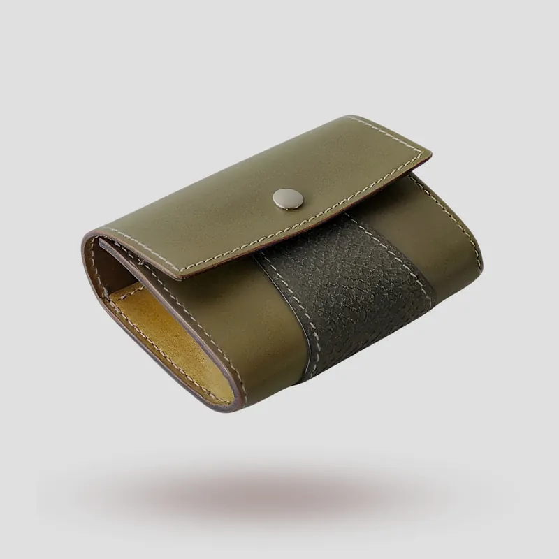 A custom wallet handcrafted in olive green premium cowhide leather, featuring a bold, asymmetrical wrap accent in salmon leather, paired with a supple goatskin lining.