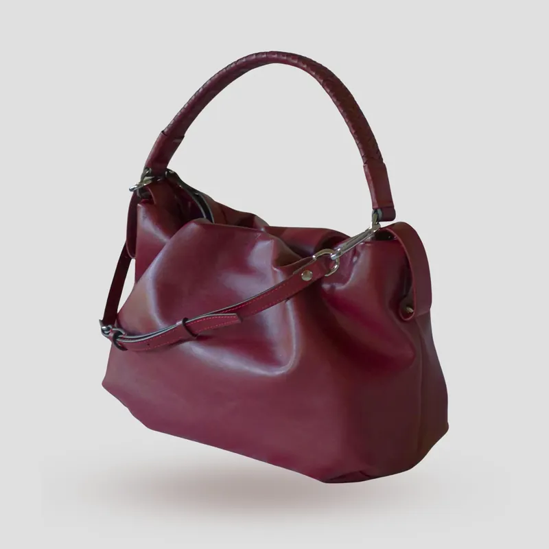 A custom soft mini bucket bag handcrafted in deep wine red full-grain aniline calfskin with a burgundy lambskin lining.