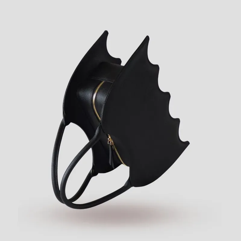 A custom bat-shaped handbag, handcrafted in black Epsom full-grain leather, with a grommet at the base of the handle for attaching charms.