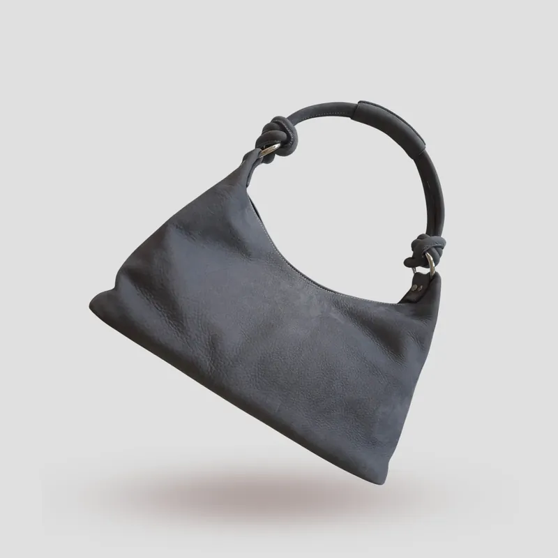 A custom hobo bag handcrafted in toned-down light blue premium nubuck with a light grey lining.