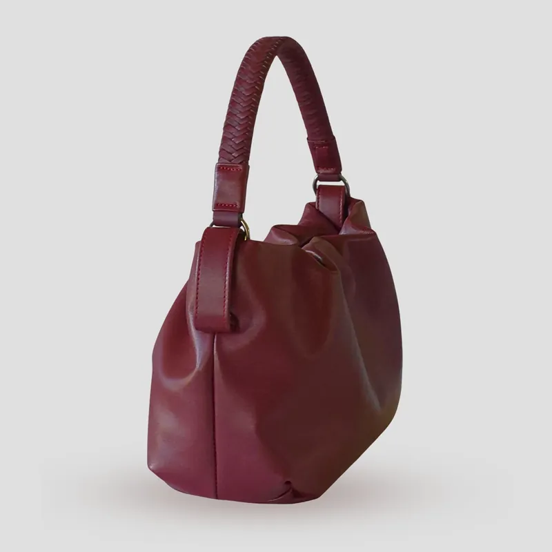 A custom soft mini bucket bag handcrafted in deep wine red full-grain aniline calfskin with a burgundy lambskin lining.