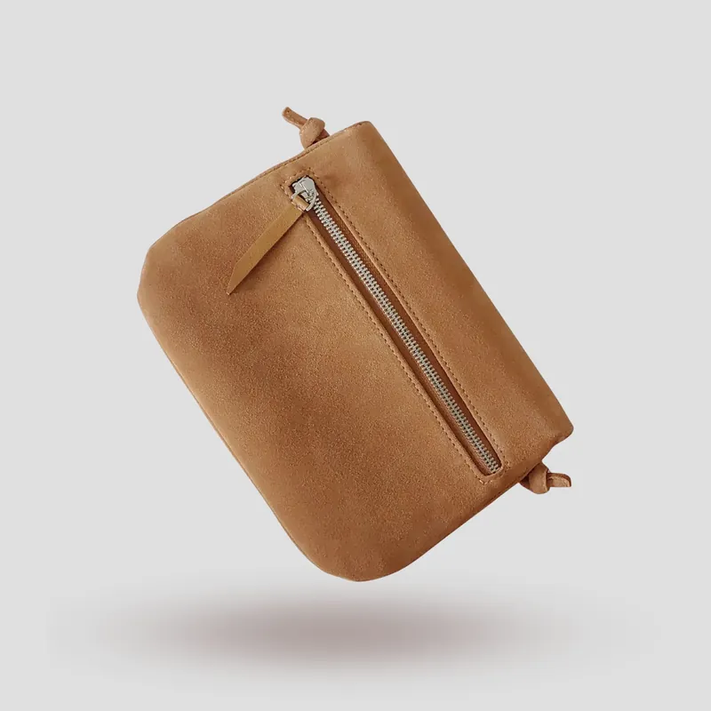 A signature crossbody bag handcrafted in beige premium suede.